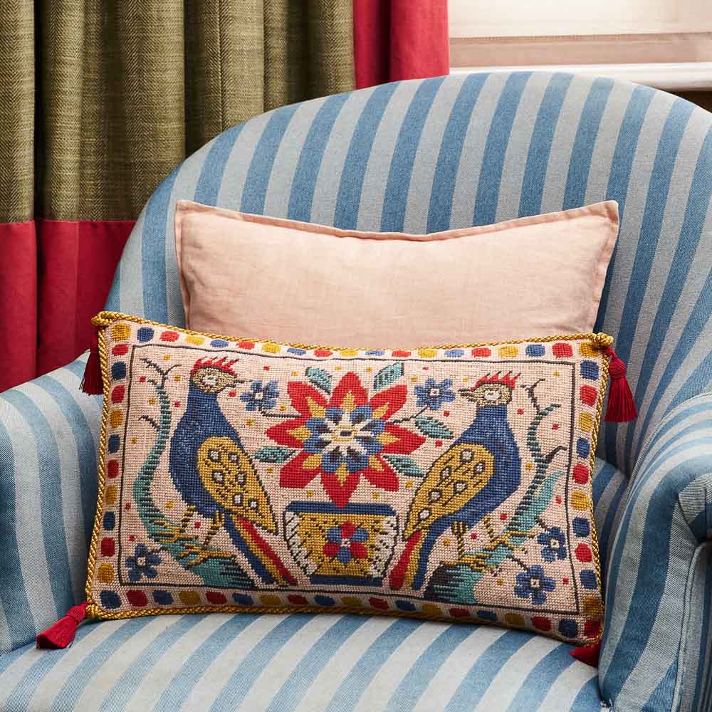 Medieval Bird pillow in a blue and white striped armchair