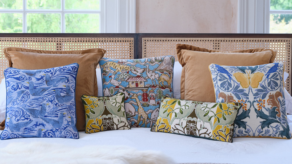 A selection of pillows based on designs from the Victoria and Albert Museum London sitting on a bed
